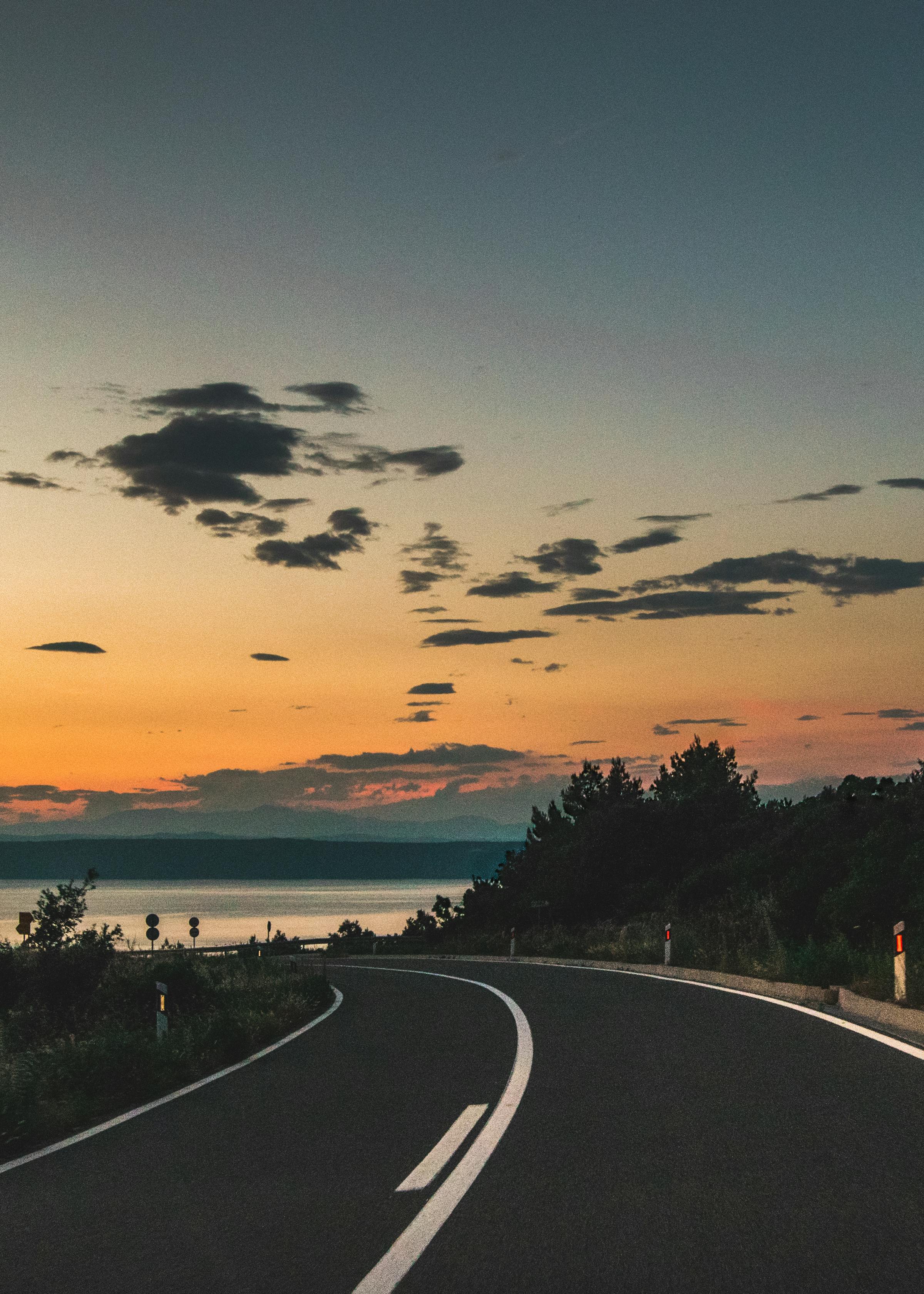 Empty coastal road at sunset